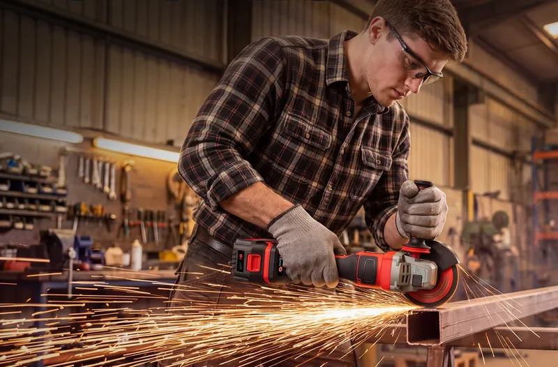 A man grinding a steel bar with the TEENO 5-inch grinder in a workshop