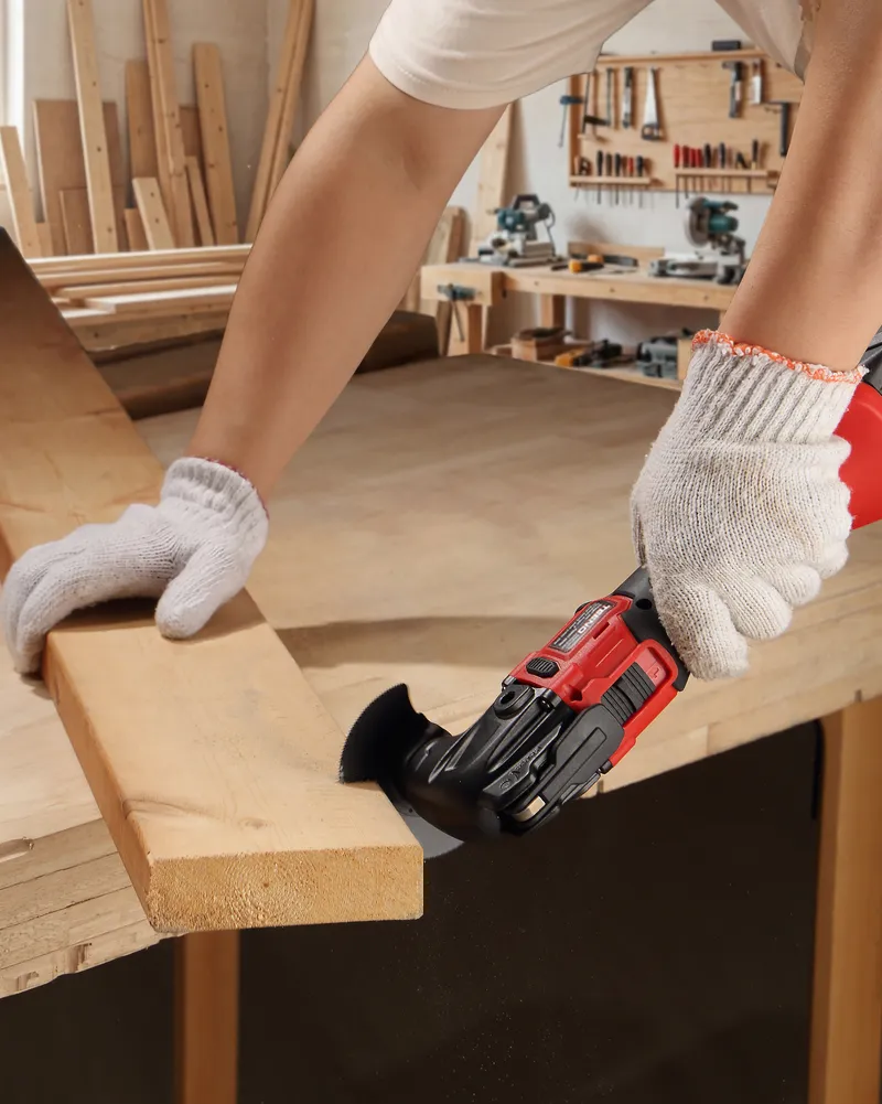 Gloved hands plunge-cutting a board with the TEENO oscillating tool